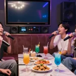 Friends singing and enjoying their time at 강남 유앤미 가라오케's vibrant karaoke room with modern decor.