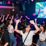 Youthful party-goers enjoying 상봉동 한국관나이트 in a vibrant nightclub atmosphere filled with colorful lights and music.